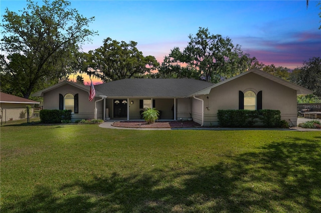 single story home featuring fence, a lawn, and stucco siding