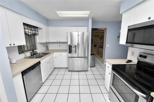 kitchen with stainless steel appliances, backsplash, a sink, and light countertops