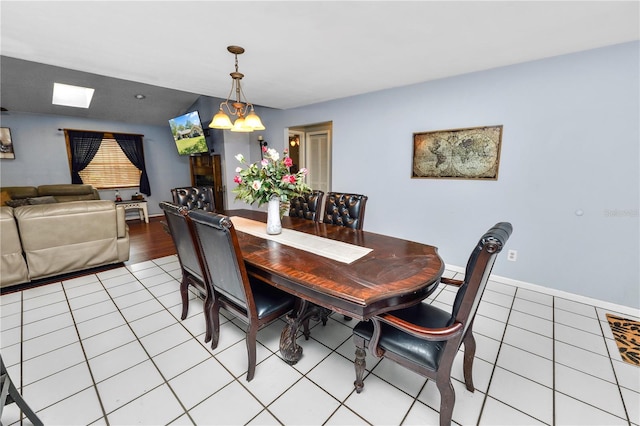 dining space with light tile patterned floors, an inviting chandelier, and baseboards