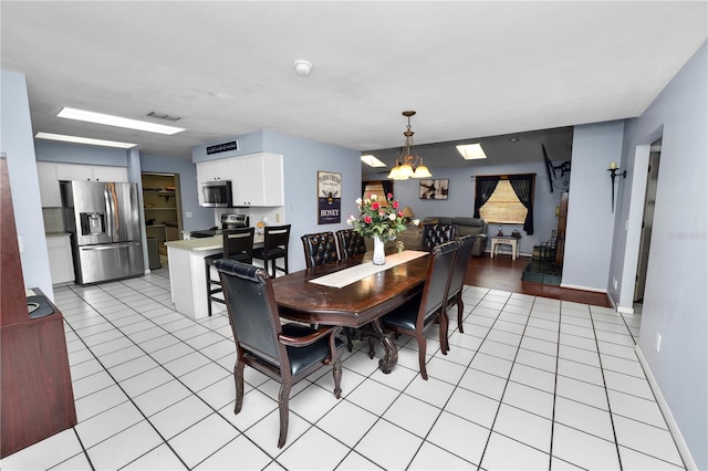 dining area with a chandelier, light tile patterned flooring, visible vents, and baseboards