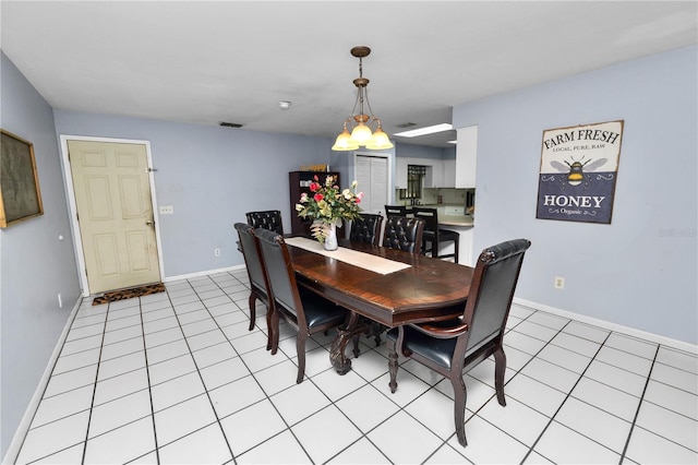 dining space featuring light tile patterned floors, visible vents, and baseboards