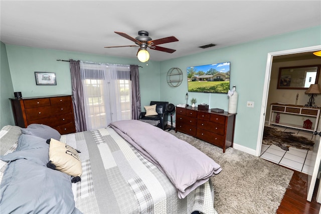 bedroom featuring ceiling fan, tile patterned flooring, visible vents, and baseboards