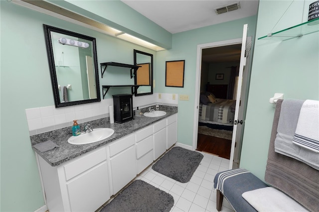 bathroom featuring double vanity, visible vents, decorative backsplash, connected bathroom, and a sink