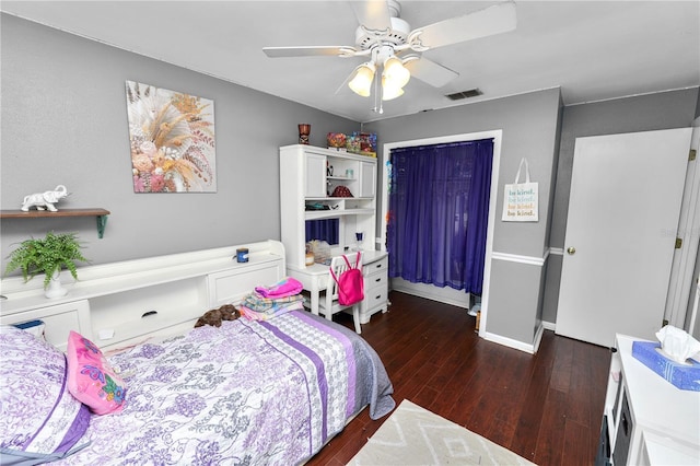 bedroom featuring hardwood / wood-style flooring, baseboards, visible vents, and a ceiling fan