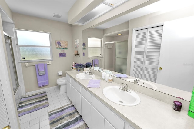 bathroom featuring a closet, a sink, visible vents, and tile patterned floors