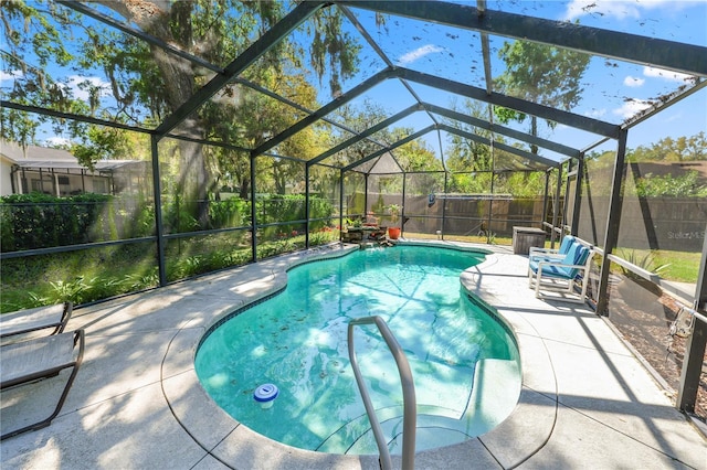 view of pool with a fenced in pool, glass enclosure, a patio area, and a fenced backyard