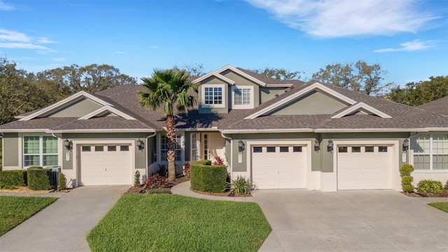 view of front of property featuring a garage, concrete driveway, and stucco siding