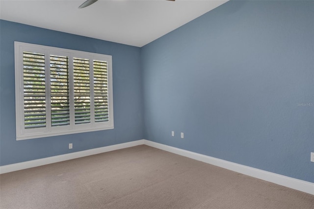 unfurnished room featuring carpet floors and baseboards