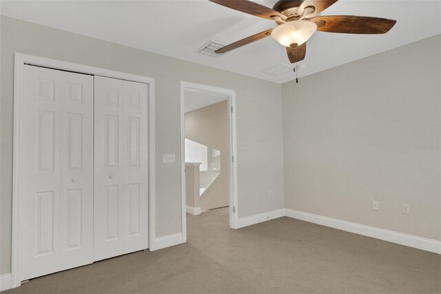 unfurnished bedroom with carpet floors, a ceiling fan, visible vents, baseboards, and a closet