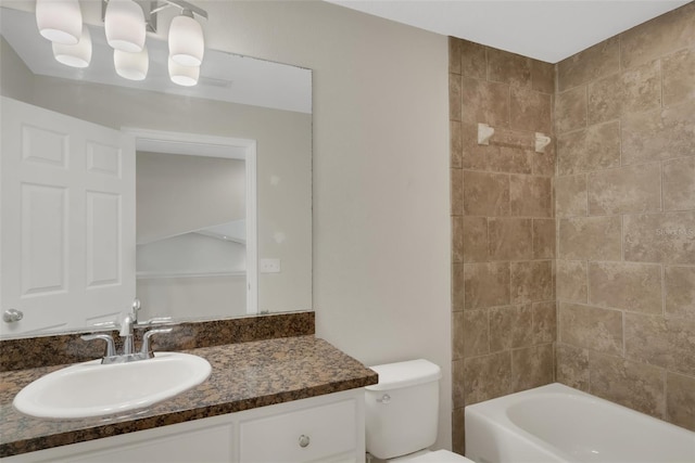 bathroom with washtub / shower combination, vanity, and toilet