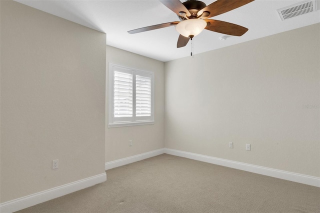 spare room featuring baseboards, visible vents, a ceiling fan, and light colored carpet