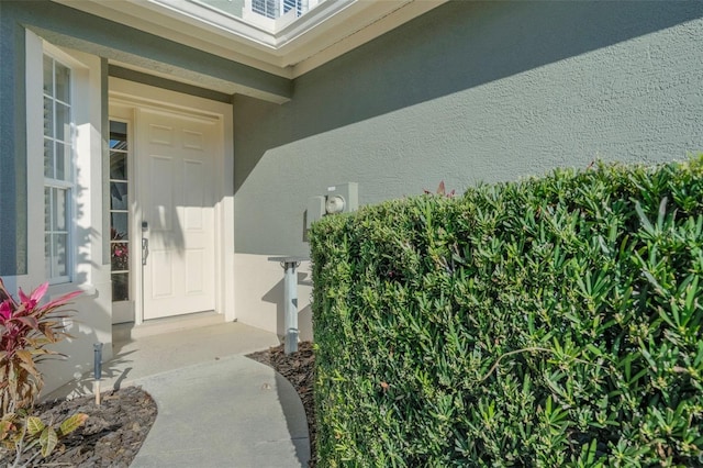 entrance to property featuring stucco siding