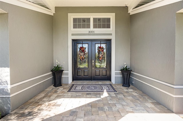 entrance to property with french doors and stucco siding