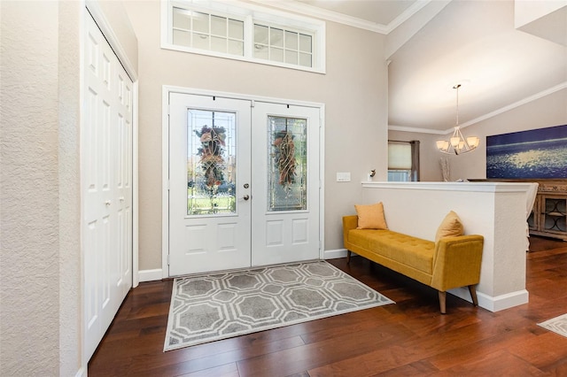 entryway featuring a notable chandelier, crown molding, baseboards, and hardwood / wood-style flooring