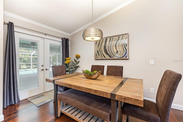 dining space featuring baseboards, dark wood-style floors, vaulted ceiling, crown molding, and french doors