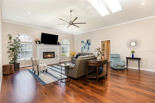 living area featuring a wealth of natural light, wood finished floors, and a glass covered fireplace