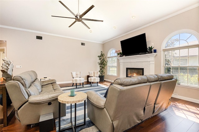 living room with a glass covered fireplace, a healthy amount of sunlight, visible vents, and wood finished floors