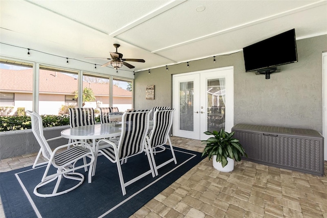 sunroom featuring a ceiling fan and french doors