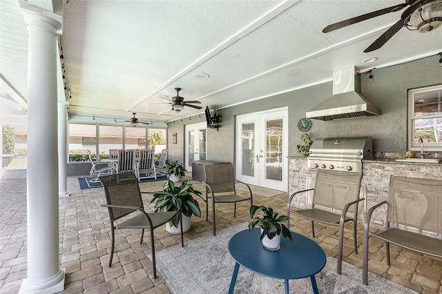 view of patio / terrace featuring ceiling fan, an outdoor kitchen, a sink, french doors, and grilling area