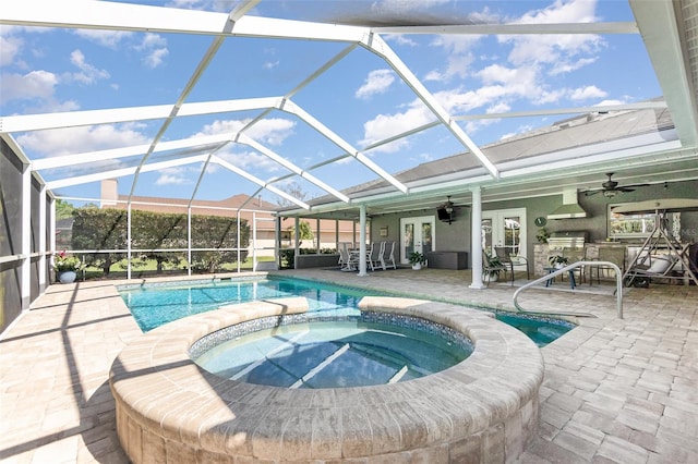 outdoor pool with a patio area, glass enclosure, an in ground hot tub, and french doors