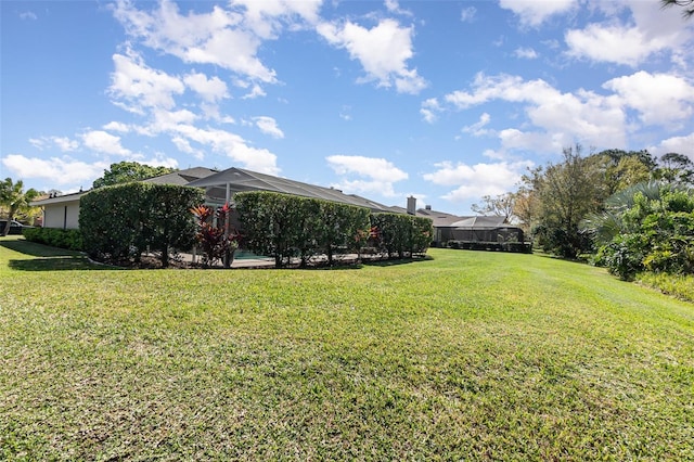 view of yard featuring a pool and glass enclosure