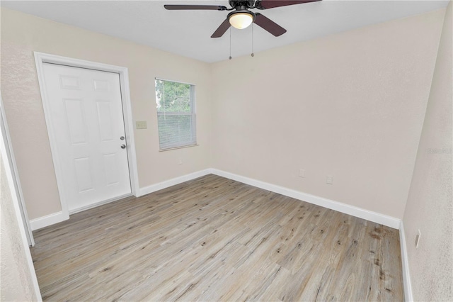 empty room featuring a ceiling fan, baseboards, and wood finished floors