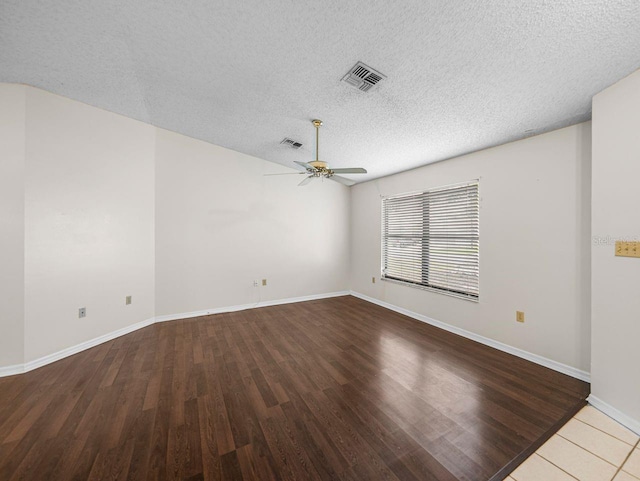 spare room featuring ceiling fan, a textured ceiling, visible vents, and wood finished floors