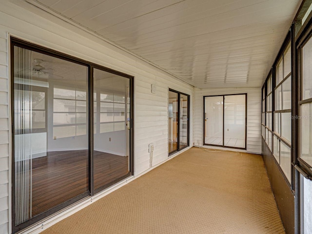 unfurnished sunroom with ceiling fan