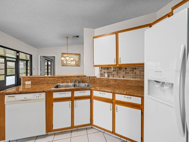 kitchen with light tile patterned floors, lofted ceiling, white appliances, a sink, and visible vents