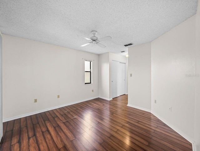 empty room with baseboards, visible vents, wood-type flooring, ceiling fan, and a textured ceiling