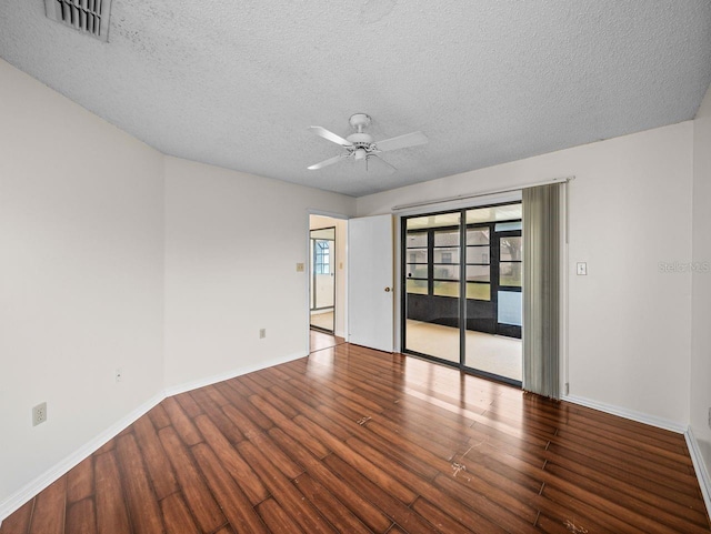 spare room featuring visible vents, ceiling fan, a textured ceiling, wood finished floors, and baseboards