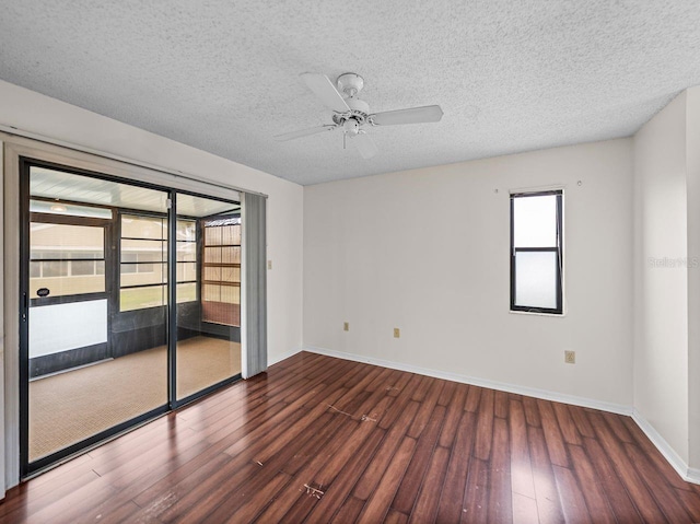 unfurnished room featuring a sunroom, a textured ceiling, baseboards, and wood finished floors