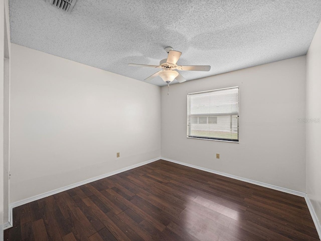 unfurnished room featuring visible vents, a textured ceiling, baseboards, and wood finished floors