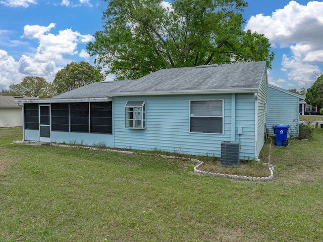 rear view of property featuring a yard, a shingled roof, cooling unit, and a sunroom