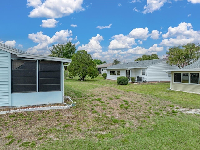 view of yard with a sunroom and central AC