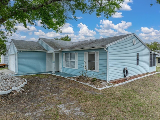 view of front of property featuring an attached garage and a front lawn