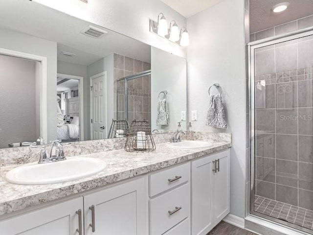 ensuite bathroom featuring ensuite bath, visible vents, a sink, and a shower stall