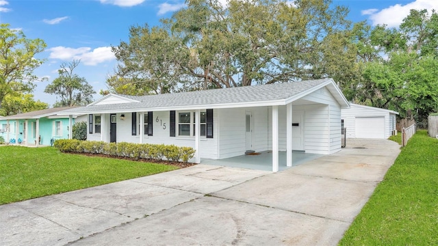 ranch-style home featuring a shingled roof, covered porch, concrete driveway, an outdoor structure, and a front lawn