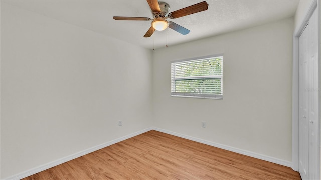 unfurnished bedroom featuring a ceiling fan, light wood-style flooring, baseboards, and a closet