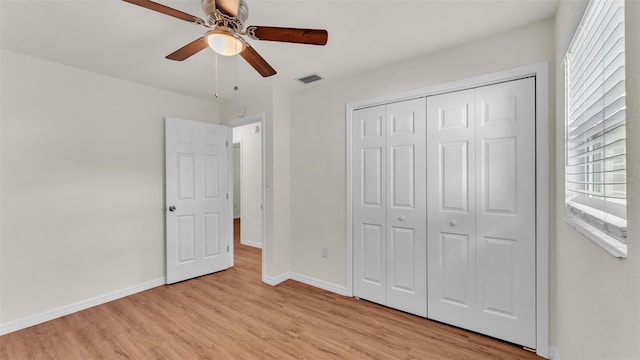 unfurnished bedroom featuring light wood finished floors, a closet, visible vents, and baseboards