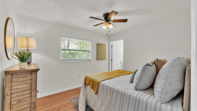 bedroom with ceiling fan, light wood finished floors, and baseboards