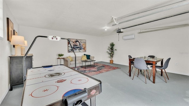 recreation room with a garage, concrete floors, and a wall mounted AC