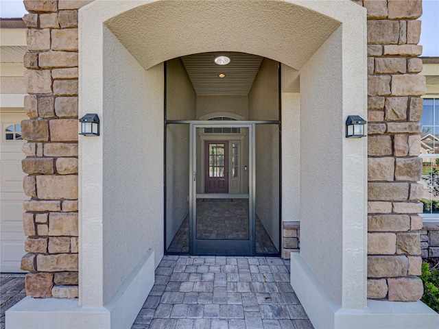 entrance to property with stone siding and stucco siding