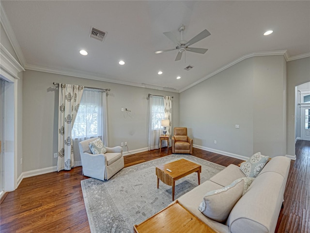 living area with baseboards, wood finished floors, visible vents, and ornamental molding