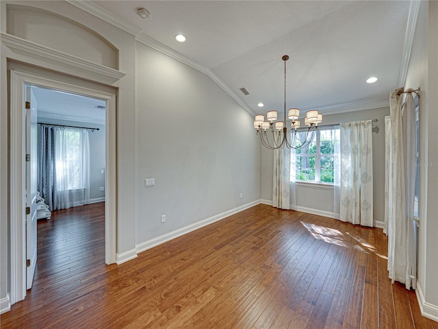 unfurnished dining area featuring hardwood / wood-style floors, visible vents, vaulted ceiling, crown molding, and a chandelier