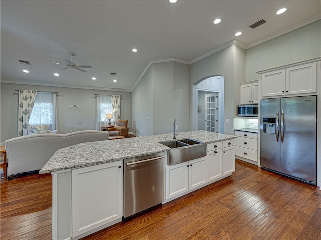 kitchen featuring visible vents, open floor plan, a center island with sink, stainless steel appliances, and a sink