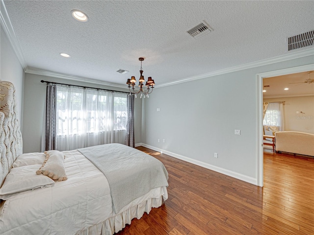 bedroom with visible vents, multiple windows, crown molding, and hardwood / wood-style floors