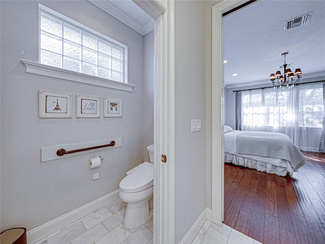 bathroom with a wealth of natural light, visible vents, connected bathroom, and toilet