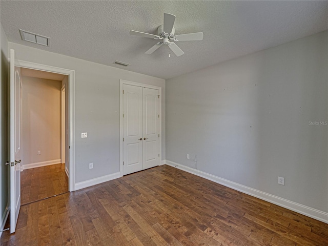 unfurnished bedroom with visible vents, baseboards, hardwood / wood-style flooring, a closet, and a textured ceiling