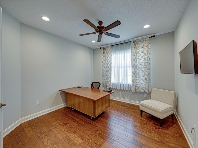 home office with ceiling fan, a textured ceiling, baseboards, and wood finished floors